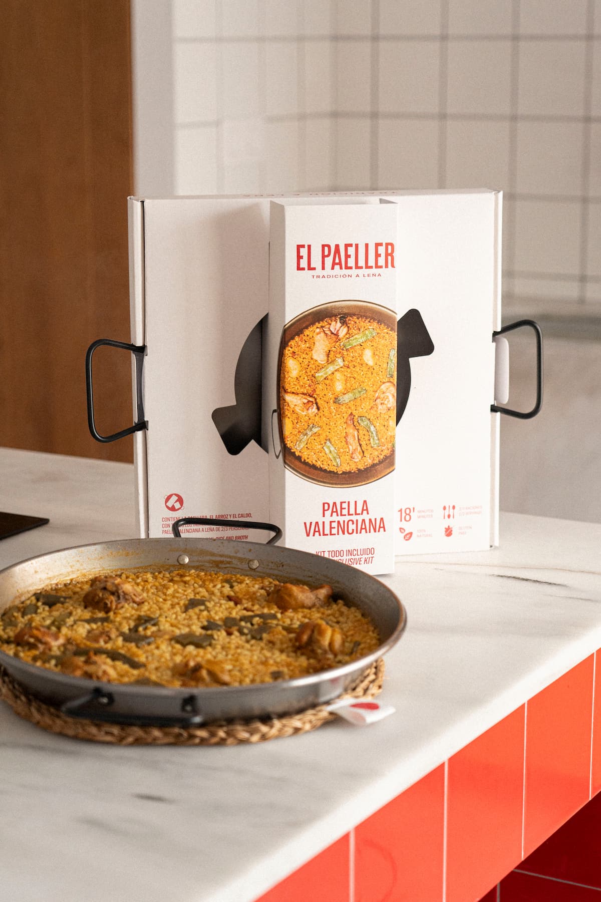 Paella in a pan with an 'El Paeller' box in the background